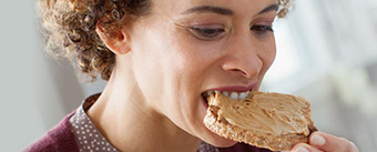 vivre avec une prothèse dentaire visuel header femme qui mange un ribs à un barbecue